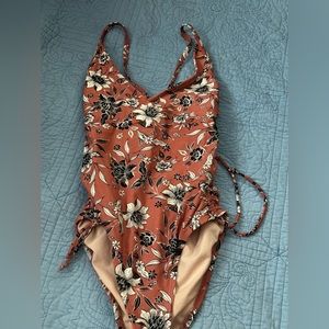 brand is kona sol its a small and is a pink color with black and white flowers.